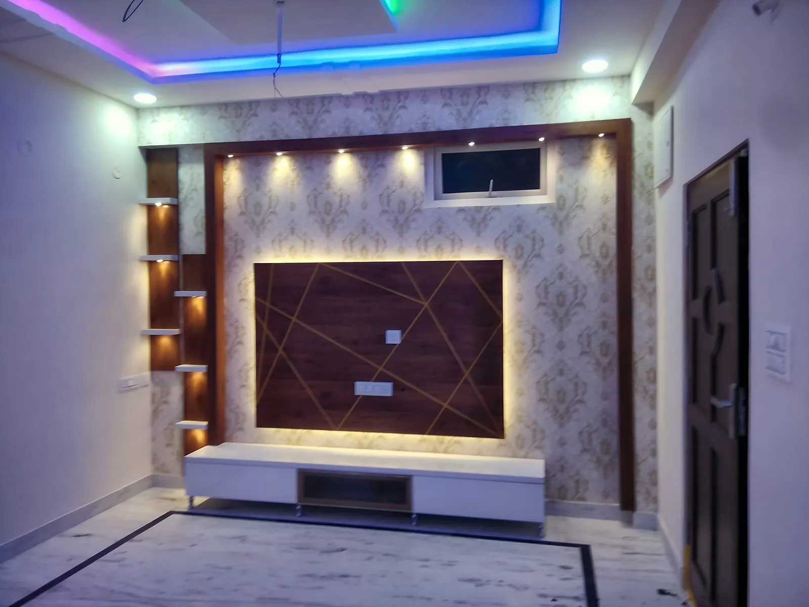 TV wall with lit shelves, panel frame and cove ceiling